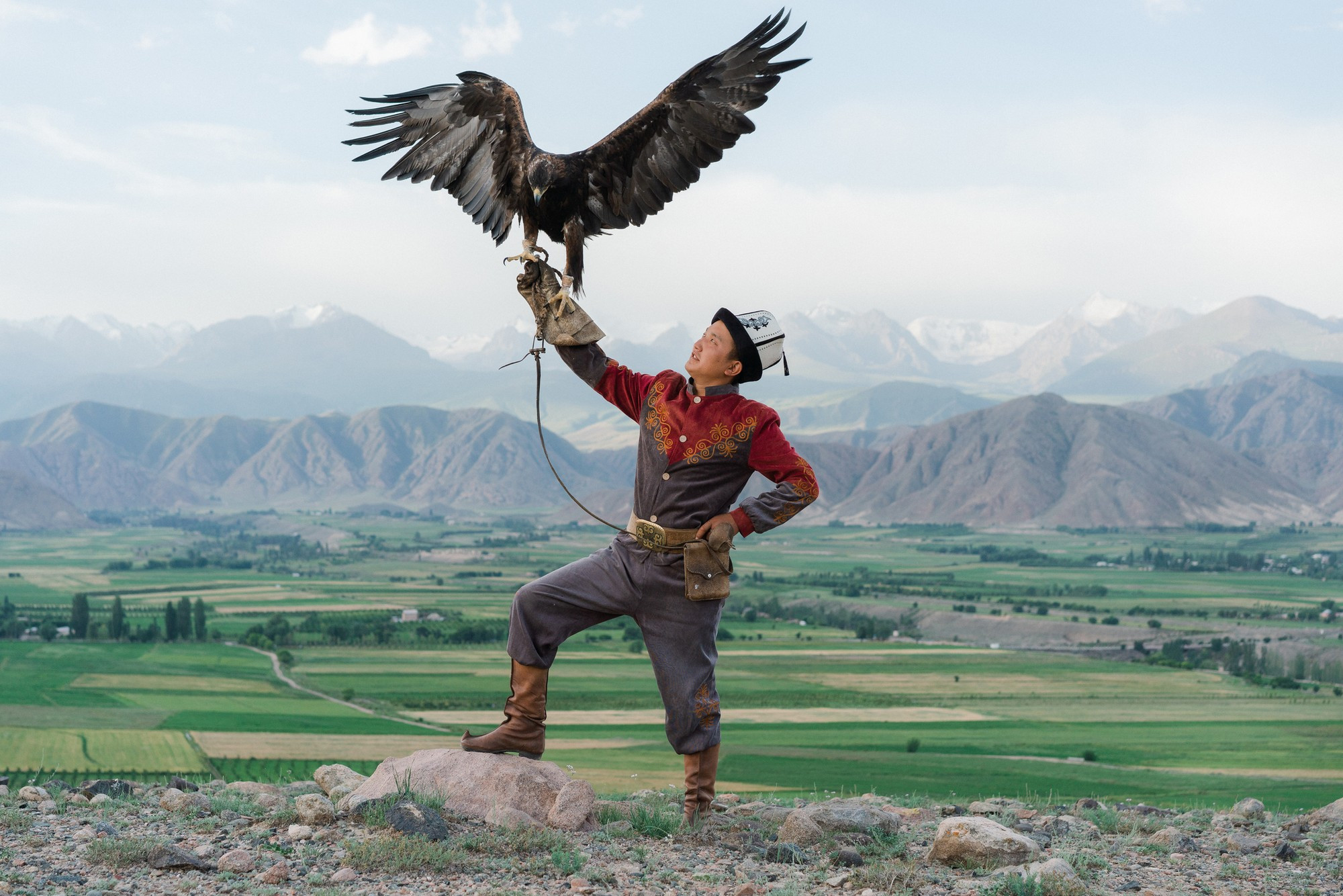 Eagle hunter standing on the background of mountains  in Kyrgyzstan
