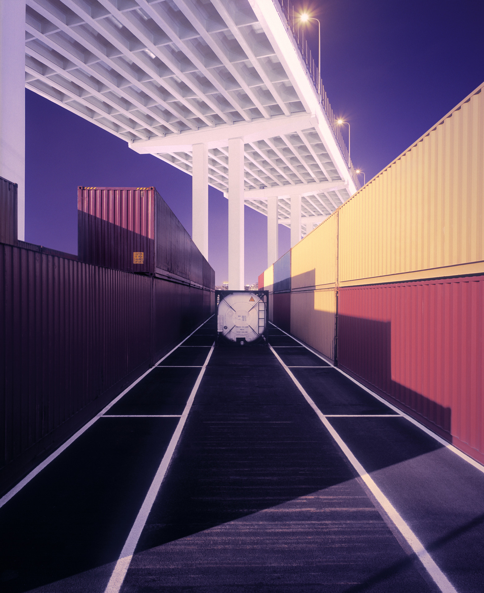 Cargo containers neatly stacked at port at dusk