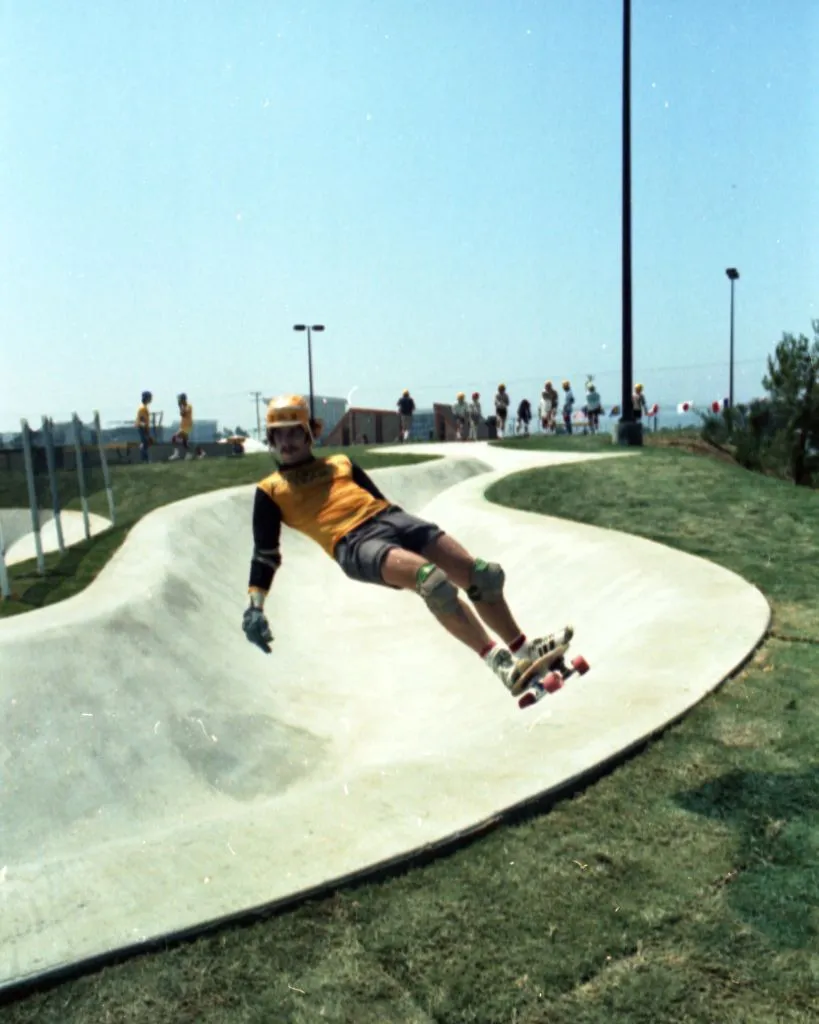 Skateboarders with Helmets and Knee Pads at the Skate Park
