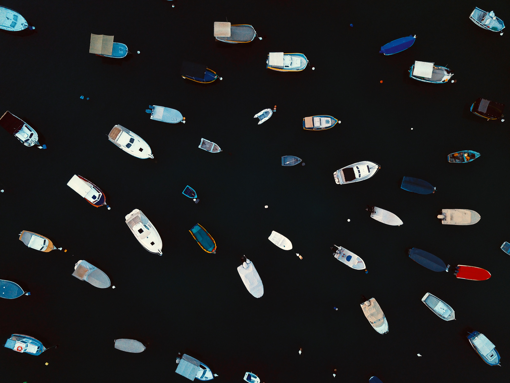 Aerial top view pattern of anchored boats at the harbour.